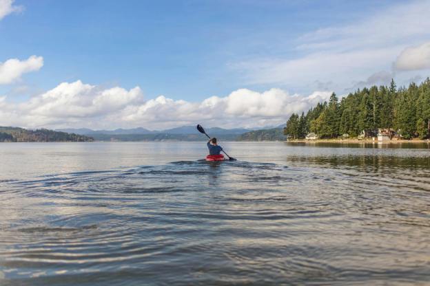 person on kayak under blue and white sky